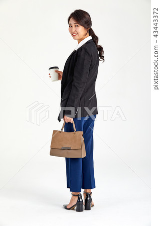 Businesswoman holding coffee in her hand in her twenties, thirties, coffee, laptop, bag 43443372