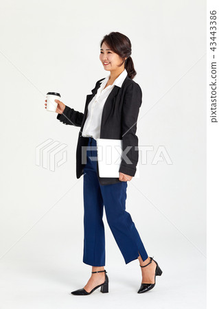 Businesswoman holding coffee in her hand in her twenties, thirties, coffee, laptop, bag 43443386