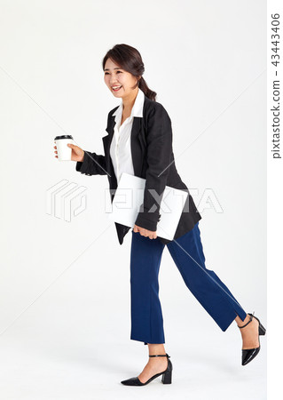 Businesswoman holding coffee in her hand in her twenties, thirties, coffee, laptop, bag Businesswoman holding coffee in her hand in her twenties, thirties, coffee, laptop, bag 43443406