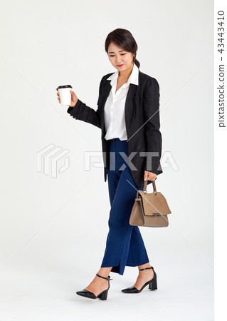 女實業家在她的二十,三十,咖啡,膝上型計算機,袋子的她的手上的拿著咖啡 女實業家在她的二十,三十,咖啡,膝上型計算機,袋子的她的手上的拿著咖啡 43443410