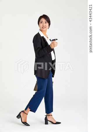 Businesswoman holding coffee in her hand in her twenties, thirties, coffee, laptop, bag 43443421