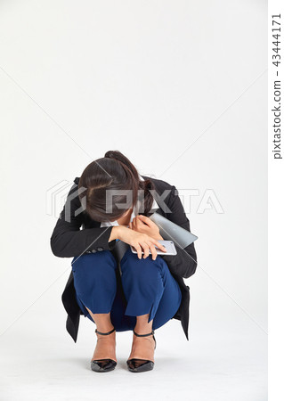 20s, 30s business woman who sits on the floor hesitantly, sadness, mood, stress, tiredness, fatigue 43444171