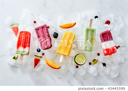 Different ice cream on a stick and different pieces of fruit and berries on ice cubes. Flat lay 43445399