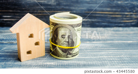 wooden house and dollars on a blue background. wooden house and dollars on a blue background. 43445580