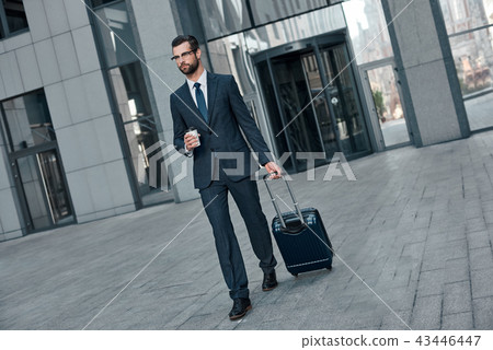 Full length of young man in full suit gesturing and shouting while walking outdoors Full length of young man in full suit gesturing and shouting while walking outdoors 43446447