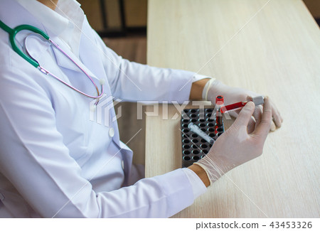 doctor holds a blood sample tube in his hand testi 43453326