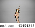 Hand Holding Golden Soda Cup  43454248