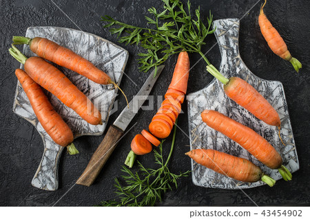 Flat lay composition with carrots on cutting board Flat lay composition with carrots on cutting board 43454902