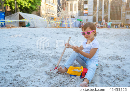 Little girl sitting in the sandbox and playing Little girl sitting in the sandbox and playing 43455323