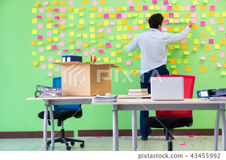 Man collecting his stuff after redundancy in the office with man Man collecting his stuff after redundancy in the office with man 43455992