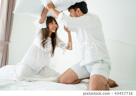 Young couple do pillow fighting in bedroom. 43457716