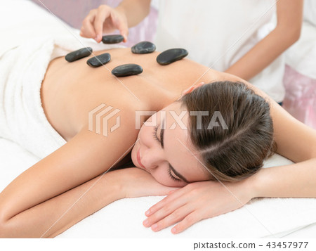 Hot stone massage treatment by therapist in spa. 43457977