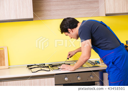 Young service contractor assembling kitchen furniture 43458501
