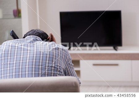 Young man watching tv at home 43458556