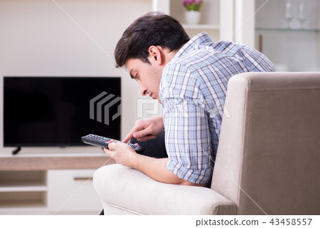 Young man watching tv at home Young man watching tv at home 43458557