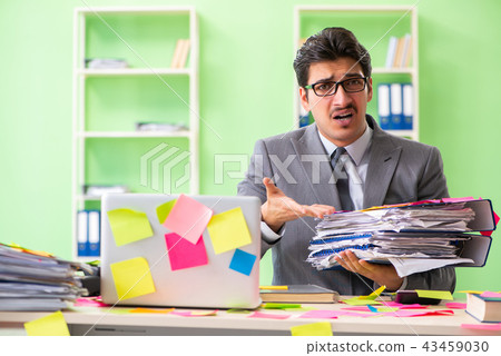 Businessman unhappy with many conflicting priorities sitting in Businessman unhappy with many conflicting priorities sitting in 43459030