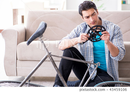 Young man repairing bicycle at home 43459106