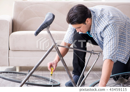 Young man repairing bicycle at home Young man repairing bicycle at home 43459115