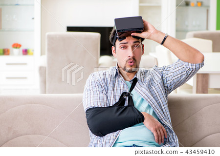 Young student man with hand injury wearing virtal glasses  43459410