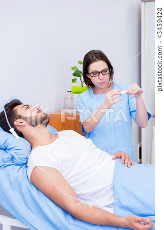 Woman doctor examining male patient in hospital 43459428