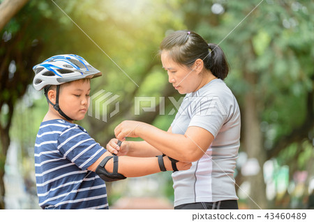 Mother wear elbow protection to his son Mother wear elbow protection to his son 43460489