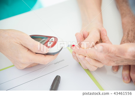 Nurse Using Glucometer On Senior Patient's Finger Nurse Using Glucometer On Senior Patient's Finger 43461556