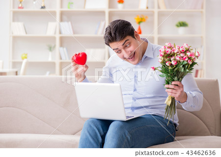 Young man making marriage proposal over internet laptop Young man making marriage proposal over internet laptop 43462636