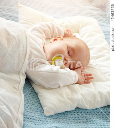 Baby sleeping covered with soft white blanket 43463266