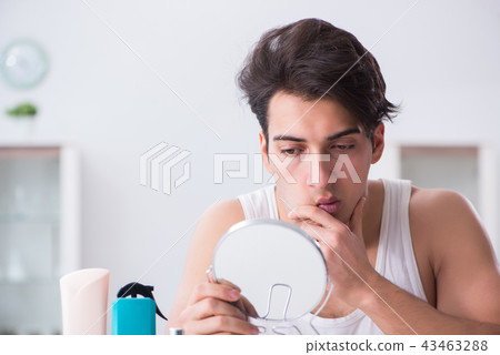Young handsome man staring in the mirror Young handsome man staring in the mirror 43463288