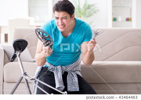 Young man repairing bicycle at home Young man repairing bicycle at home 43464463