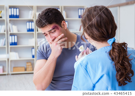 Young man visiting female traumatologist with black eye Young man visiting female traumatologist with black eye 43465415