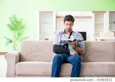 Young student man with hand injury sitting on the sofa  43465651