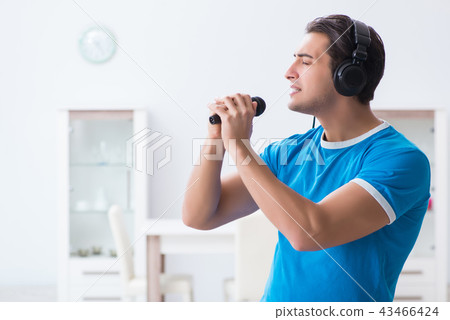 Young handsome man singing karaoke at home  43466424