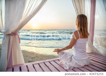 Woman meditating at the sea Woman meditating at the sea 43473233