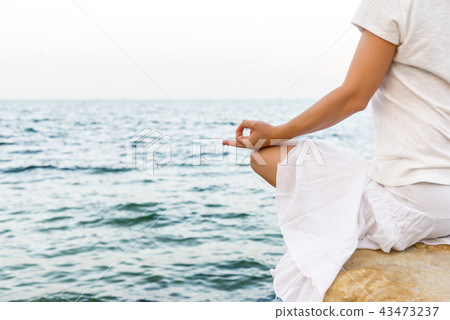 Woman meditating at the sea Woman meditating at the sea 43473237