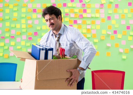 Man collecting his stuff after redundancy in the office with man 43474016