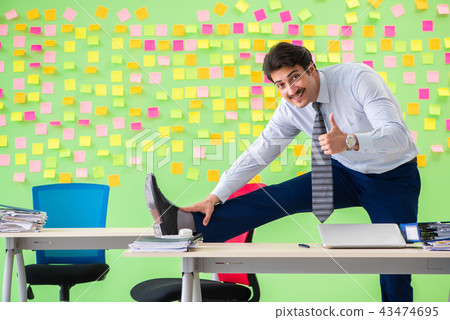 Man in the office with many conflicting priorities doing exercis 43474695