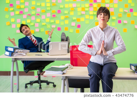 Man and woman in the office with many conflicting priorities in  43474776
