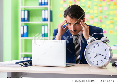 Businessman with many conflicting priorities in time management Businessman with many conflicting priorities in time management 43474875