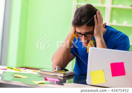 Young doctor sitting in hospital with many conflicting prioritie Young doctor sitting in hospital with many conflicting prioritie 43475452