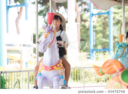 A child riding a merry-go-round A child riding a merry-go-round 43478748
