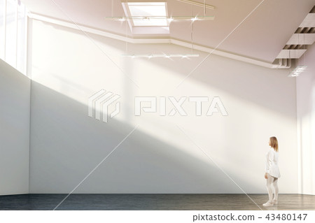 Woman walking near blank white wall mockup in modern gallery Woman walking near blank white wall mockup in modern gallery 43480147
