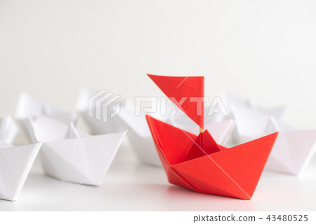 Red paper ship lead among white ship 43480525
