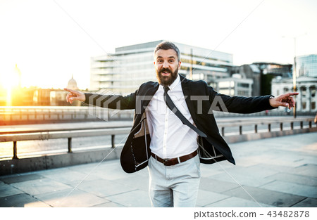 Cheerful hipster businessman walking on the bridge in the city, arms stretched. Cheerful hipster businessman walking on the bridge in the city, arms stretched. 43482878
