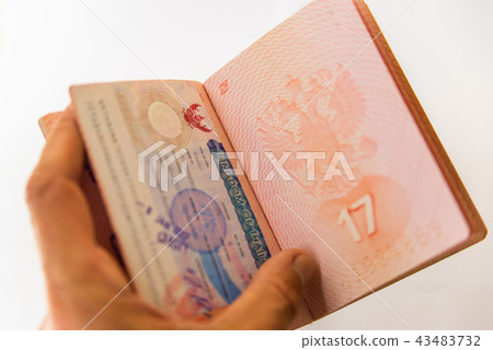 Thai visa stamp in russian passport in mens hand Thai visa stamp in russian passport in mens hand 43483732