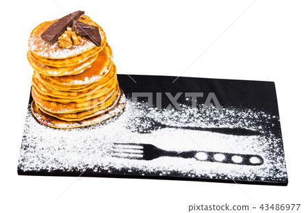 Pancakes served chocolate, walnut and powdered sugar at plate 43486977