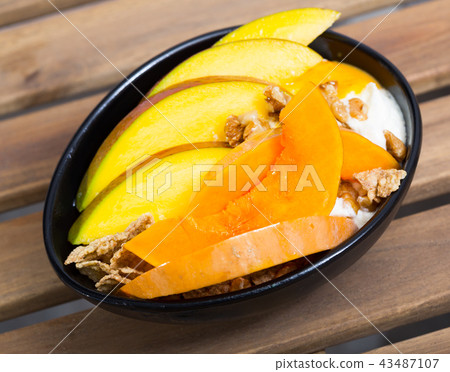 Mango slices and baked pumpkin with yogurt, cereals, nuts Mango slices and baked pumpkin with yogurt, cereals, nuts 43487107
