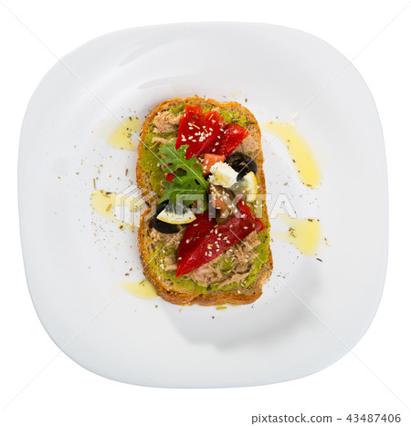 Top view of sandwich with guacamole, canned tuna, feta, vegetables on white plate 43487406