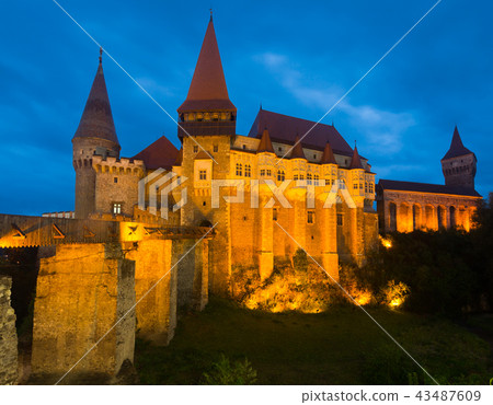Corvin Castle is on the green mountain in night 43487609