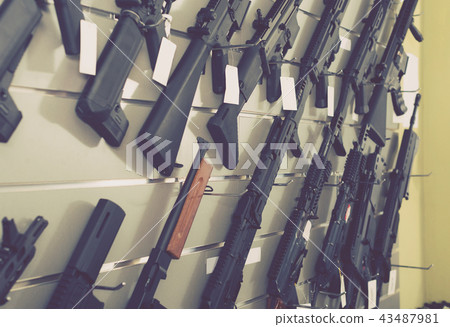 air-driven rifle hangs on the wall in army store 43487981